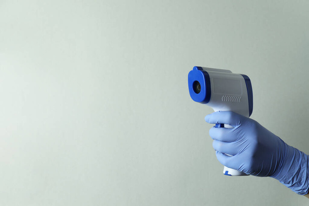 Eldivenli tutuş termometre tabancası, metin için boşluk - Fotoğraf, Görsel