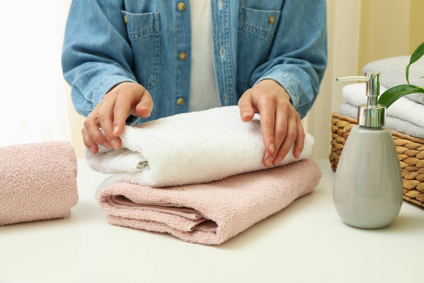 Jovem mulher dobra toalhas limpas, close-up - Foto, Imagem