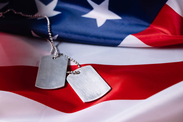 Amerykańska flaga i wojskowe nieśmiertelniki. Koncepcja Dnia Pamięci USA. - Zdjęcie, obraz