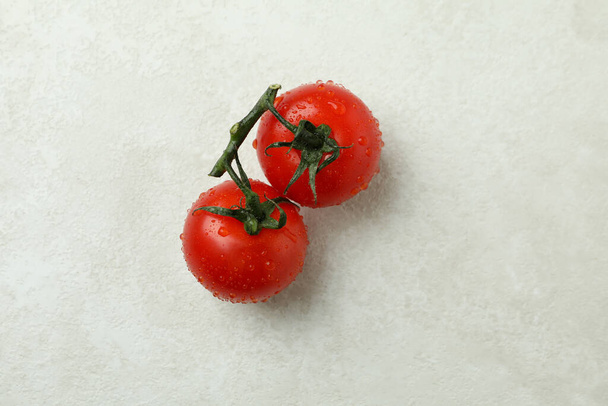 Свіжий вишневий помідор на білому текстурованому фоні, крупним планом
 - Фото, зображення