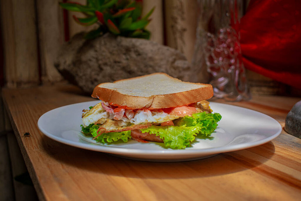 Sandwich mit Gemüse auf weißem Teller mit Felshintergrund - Foto, Bild