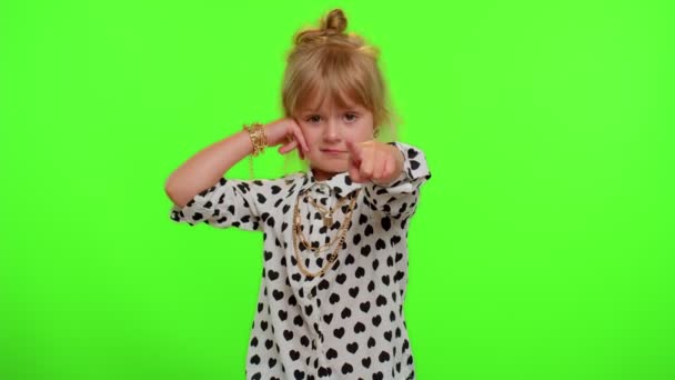 Little cute blonde child girl looking at camera doing phone gesture like says hey you call me back - Footage, Video