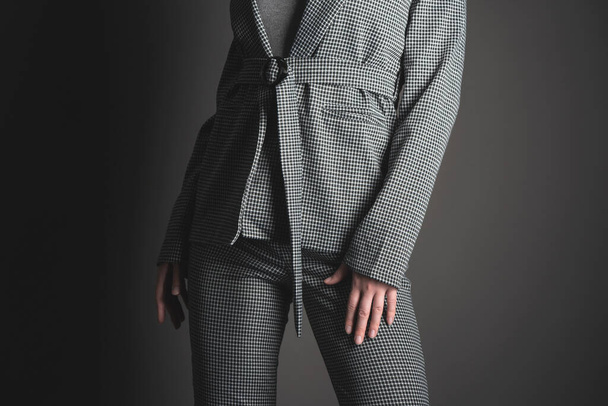 Woman in the gray suit is posing on the gray background. - Foto, immagini