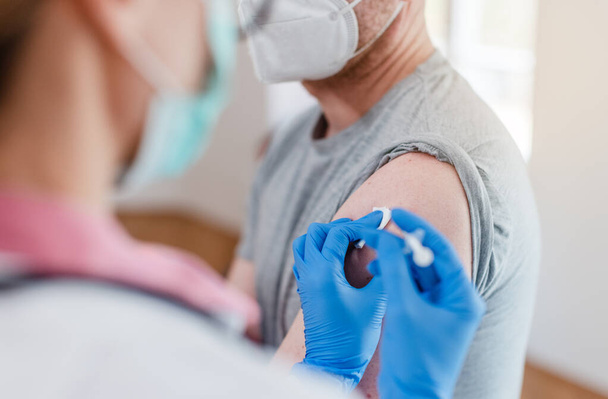 Человек, получающий вакцину против ковида 19 - Фото, изображение