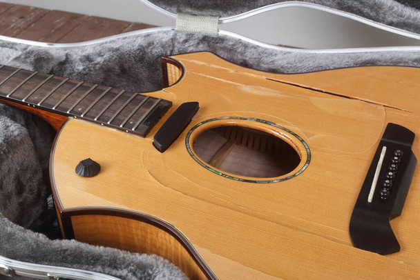 Instrumento musical - Fragmento de primer plano Guitarra acústica rota en estuche duro - Foto, imagen
