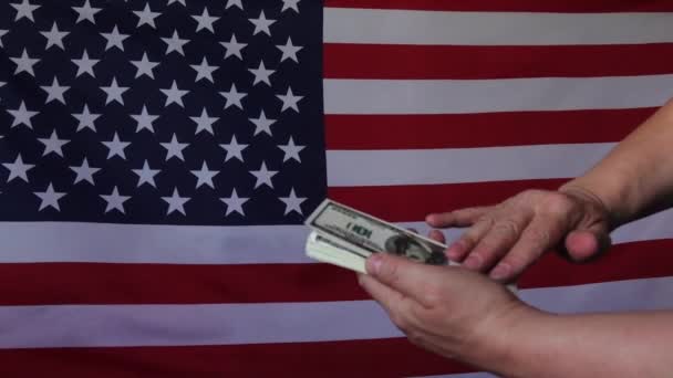 Dollari in caduta sullo sfondo della bandiera americana.In slow motion. Pioggia di soldi. - Filmati, video