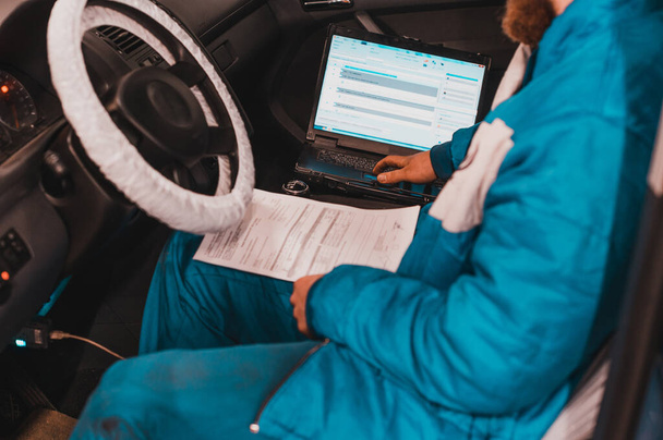 Diagnóstico informático de la computadora de a bordo en el coche en un concesionario de automóviles. - Foto, imagen