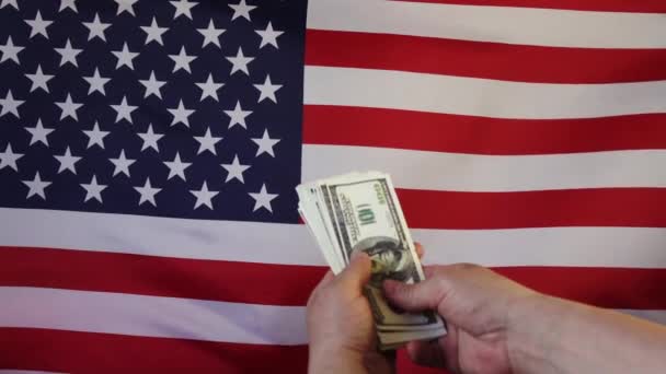 Zuhanó dollár a háttérben az amerikai zászló.Lassított felvételen. Pénzeső. - Felvétel, videó