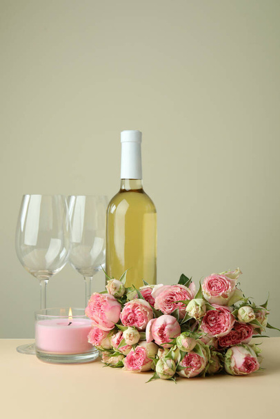 Concept romantique avec roses, vin et bougie sur table beige - Photo, image