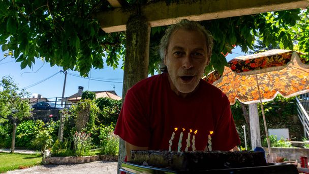 hombre de mediana edad a punto de soplar velas de cumpleaños - Foto, Imagen
