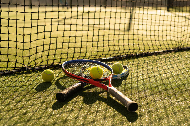 Una racchetta da tennis e una nuova pallina da tennis su un campo da tennis appena dipinto - Foto, immagini