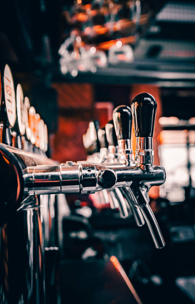 many beer taps in bar or pub - Valokuva, kuva
