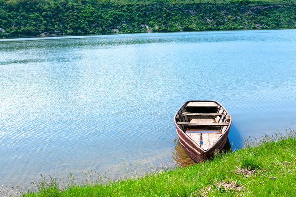 Köy balıkçılığı için tahta kayık. Kıyıya demir atmış küçük bir tekne. - Fotoğraf, Görsel
