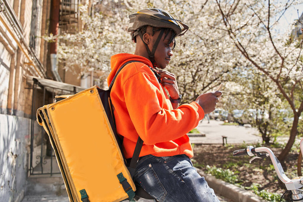 Man courier using a map app on mobile phone to find the delivery address - 写真・画像