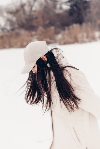 Stylový zimní focení krásné ženy uprostřed ledového jezera v malém městečku.  - Fotografie, Obrázek