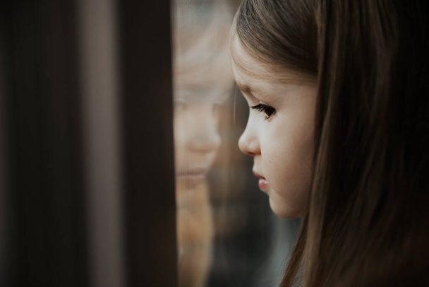 photo of a girl looking out the window - Foto, Bild