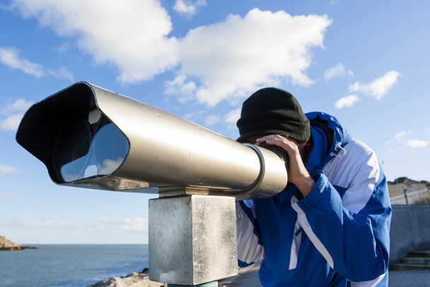 Homem olhando para a frente por telescópio
 - Foto, Imagem