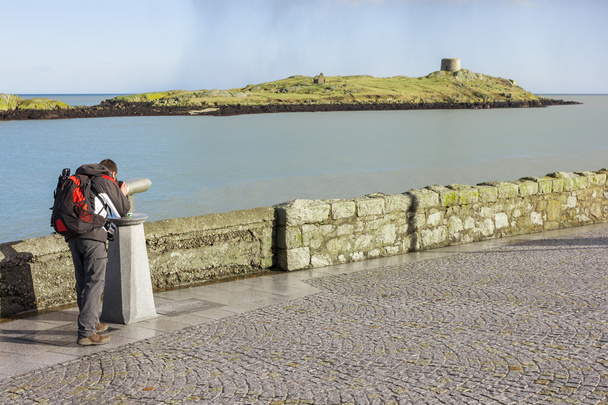 Человек смотрит на остров Далки с помощью бинокля
 - Фото, изображение