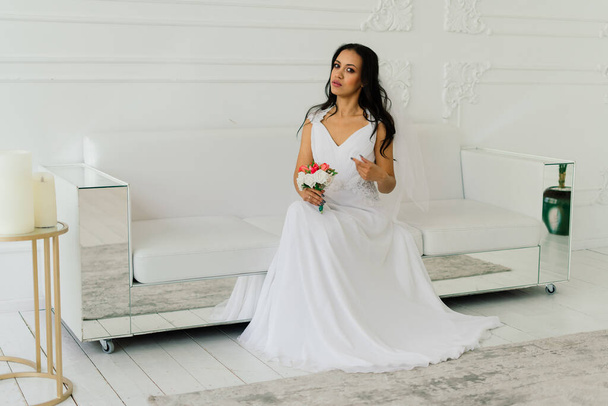 Glücklich schöne Braut mit ihrem Schleier lächelnd und aufgeregt in einem Interieur, Hochzeitsmorgen - Foto, Bild