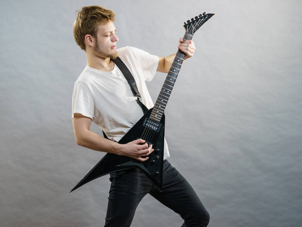 Man being passionate about his music hobby, playing electric guitar emotionally. - Photo, Image