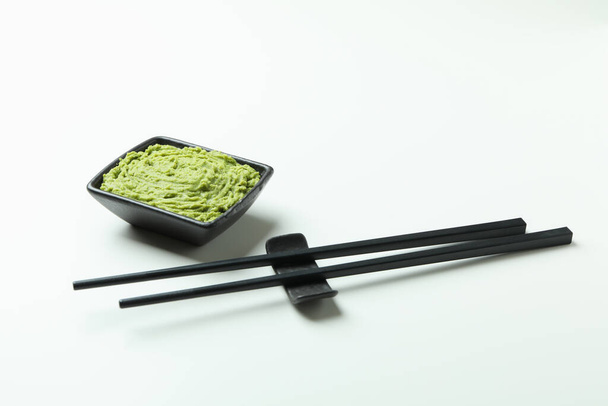 eetstokjes en wasabi saus op witte achtergrond - Foto, afbeelding