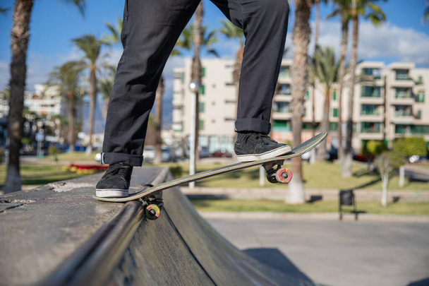Skateboarder se baja de la rampa con su patín durante un fantástico día soleado en Tenerife - Foto, imagen