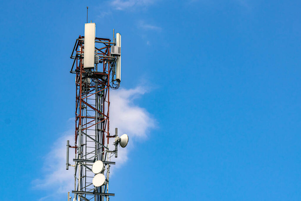 Телекомунікаційна вежа з хмарами та небом на задньому плані
 - Фото, зображення