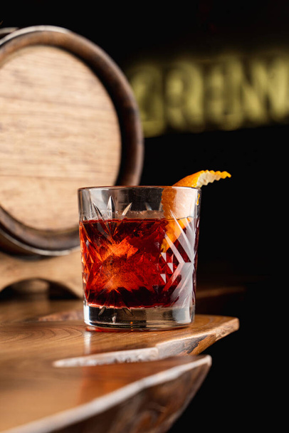 Beautiful and posh photo of negroni cocktail for a mixology magazine cover, close up, dark atmosphere - Foto, imagen