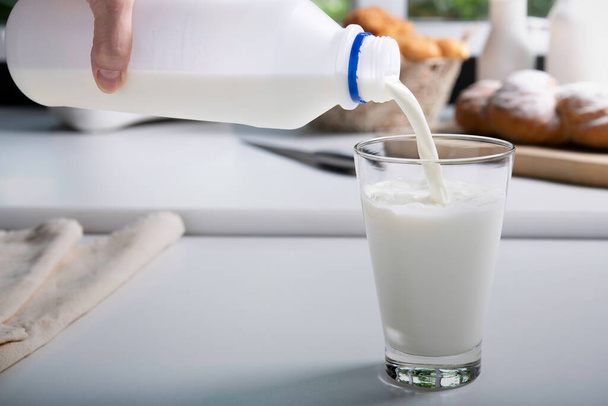 Выливание молока в стекло на кухне - Фото, изображение