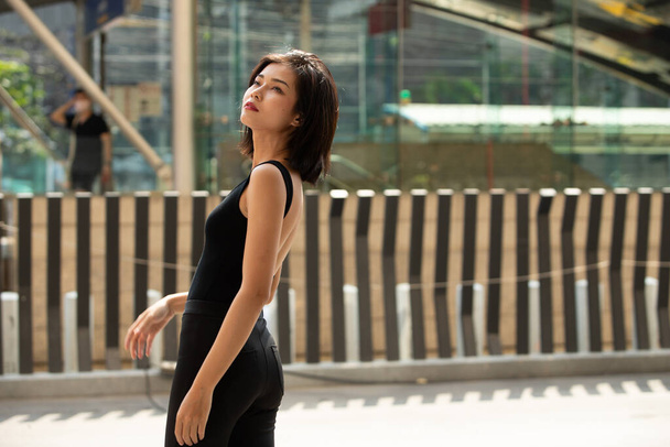 ハーフボディ20代のアジア女性ストレート黒髪の肖像は、正式なドレスシャツを着用。女性は買い物のために屋外の通りを歩くことが幸せ感じている - 写真・画像
