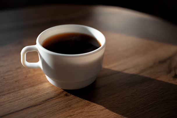 Detailní záběr na keramický šálek kávy na dřevěném stole. - Fotografie, Obrázek
