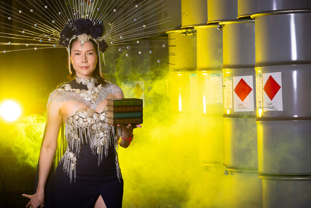 Высокомодная азиатская модель носит платье с макияжем для нового сезона моды. SuperModel быть съемки моды фотографии в желтой подсветке бочки стальной завод, дым копирования пространства - Фото, изображение