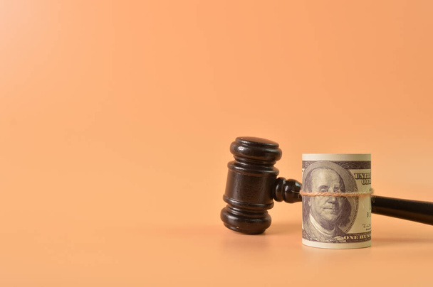 Judge gavel and money banknote isolated on orange background with copy space. - Foto, Imagem