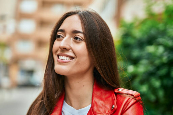 jonge Spaanse vrouw glimlachend gelukkig staande in de stad. - Foto, afbeelding