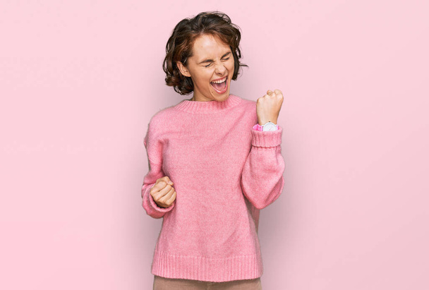 Young hispanic woman wearing casual clothes celebrating surprised and amazed for success with arms raised and eyes closed. winner concept.  - Photo, Image
