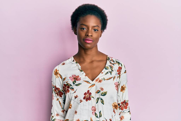 Young african american girl wearing casual clothes relaxed with serious expression on face. simple and natural looking at the camera.  - 写真・画像