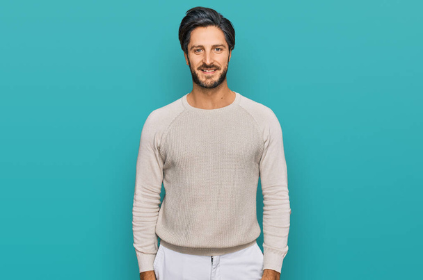 Молодий іспаномовний чоловік в повсякденному одязі виглядає позитивним і щасливим стоячи і посміхаючись з впевненою посмішкою, показуючи зуби
  - Фото, зображення