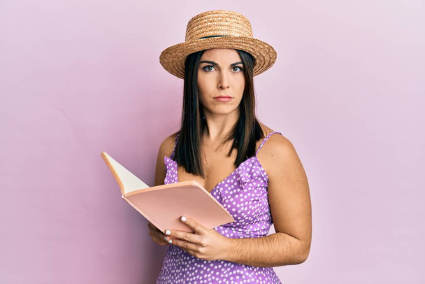 Young brunette woman reading book skeptic and nervous, frowning upset because of problem. negative person.  - Fotoğraf, Görsel