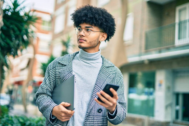 Nuori afrikkalainen amerikkalainen liikemies, jolla on vakava ilme älypuhelimen avulla kaupungissa. - Valokuva, kuva
