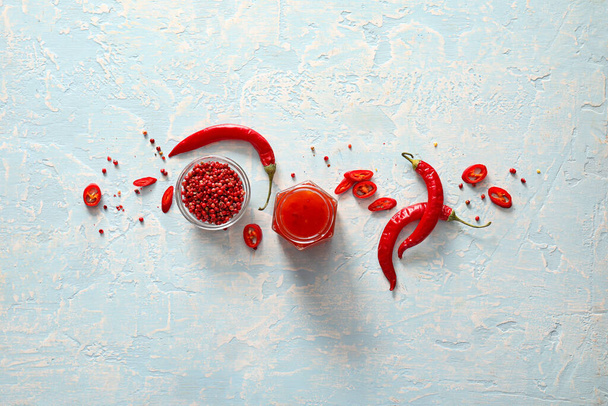 Composição com molho de pimenta saboroso e ingredientes sobre fundo de cor - Foto, Imagem
