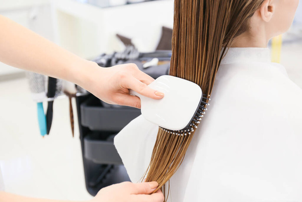 Kobieta fryzjer czesanie mokre włosy klienta w salonie piękności - Zdjęcie, obraz
