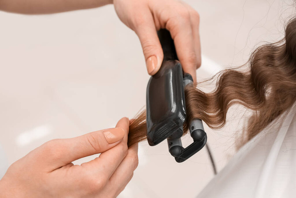 Жіночий перукар завивання волосся клієнта в салоні краси, крупним планом
 - Фото, зображення