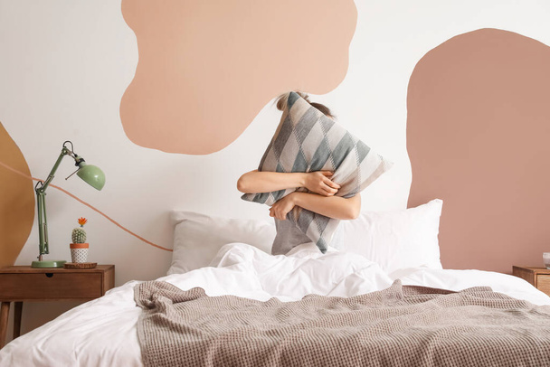 Śpiąca młoda kobieta przytula poduszkę w sypialni - Zdjęcie, obraz