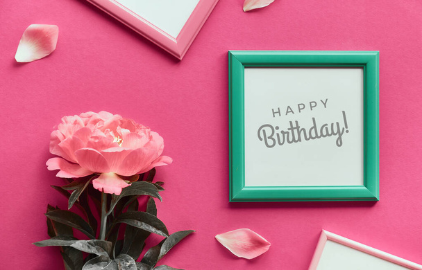 Happy Birthday greeting card, peony flowers and picture frames. Pink peony in white frame. Creative flat lay, top view on vibrant pink paper. - Zdjęcie, obraz