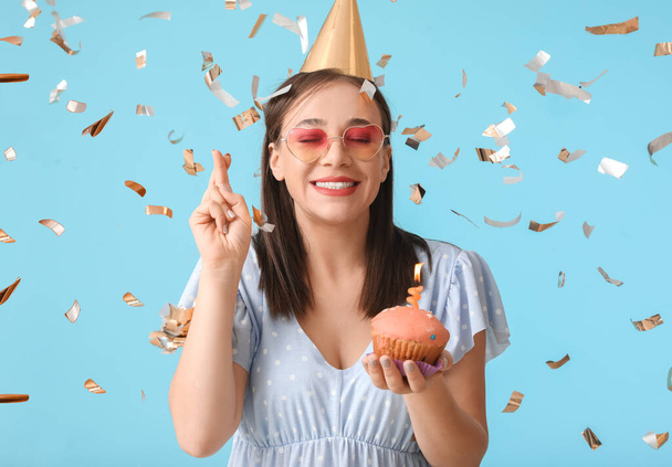 Young woman celebrating birthday on color background - Foto, imagen