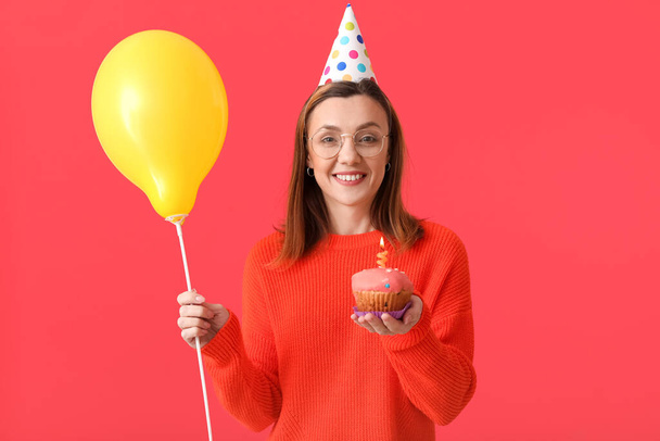 Krásná žena slaví narozeniny na barevném pozadí - Fotografie, Obrázek