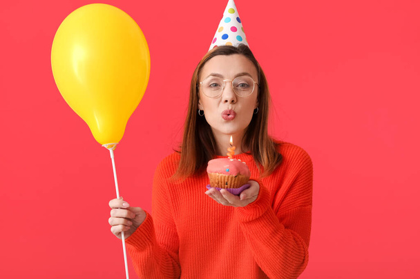 Hermosa mujer celebrando cumpleaños en el fondo de color - Foto, imagen