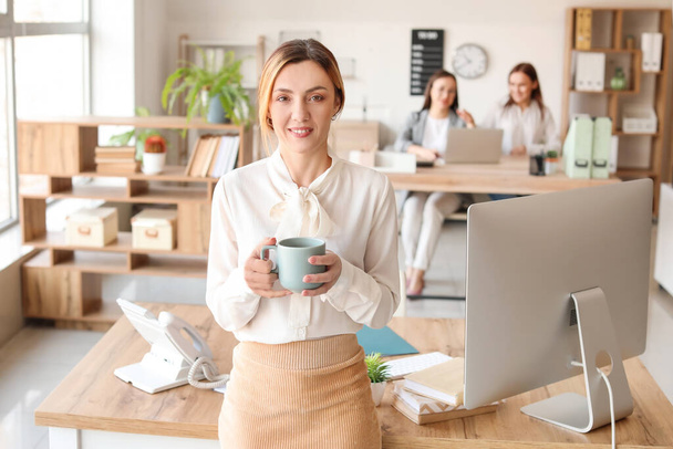 Žena účetní s šálkem kávy v kanceláři - Fotografie, Obrázek