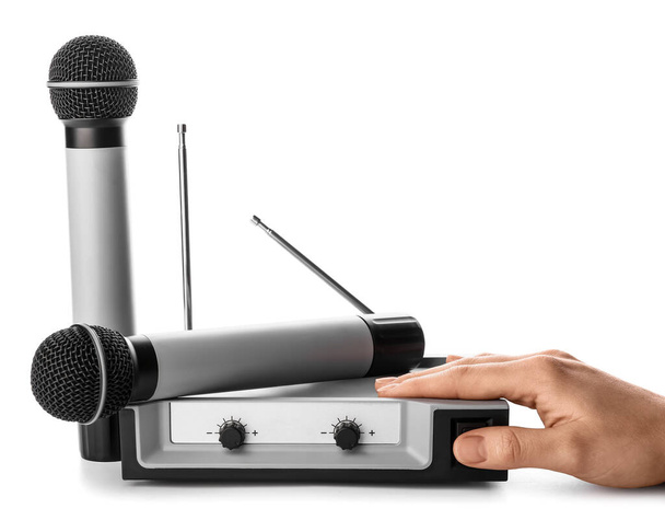 Female hand with modern microphones and audio system on white background - Photo, Image
