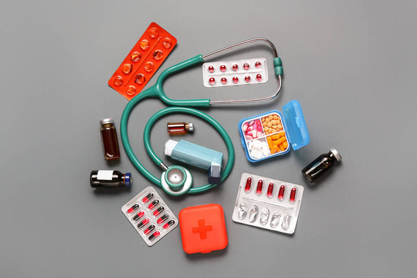 Inhaler gyógyszerekkel és sztetoszkóppal szürke alapon - Fotó, kép